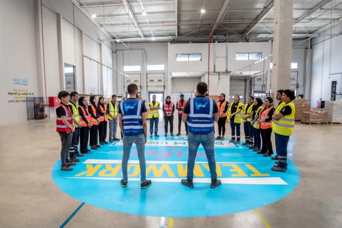 Préparation d'une commande au Wasal Fulfillment Center — emballage soigné aux couleurs Wasal